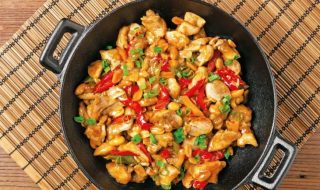 Chicken kung pao. Fried chicken pieces with peanuts and peppers. Top view. Flat lay.