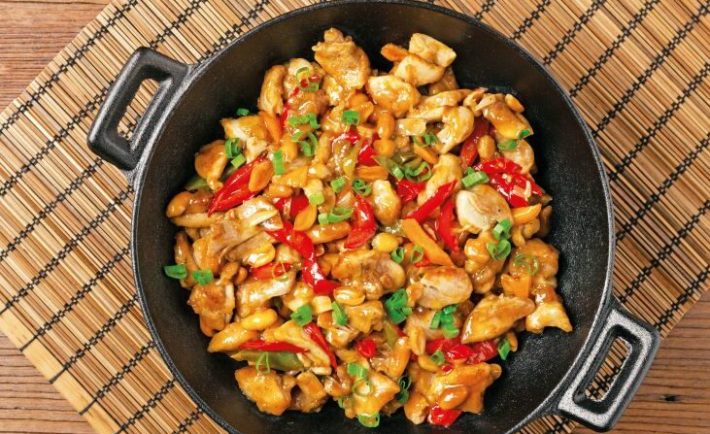 Chicken kung pao. Fried chicken pieces with peanuts and peppers. Top view. Flat lay.